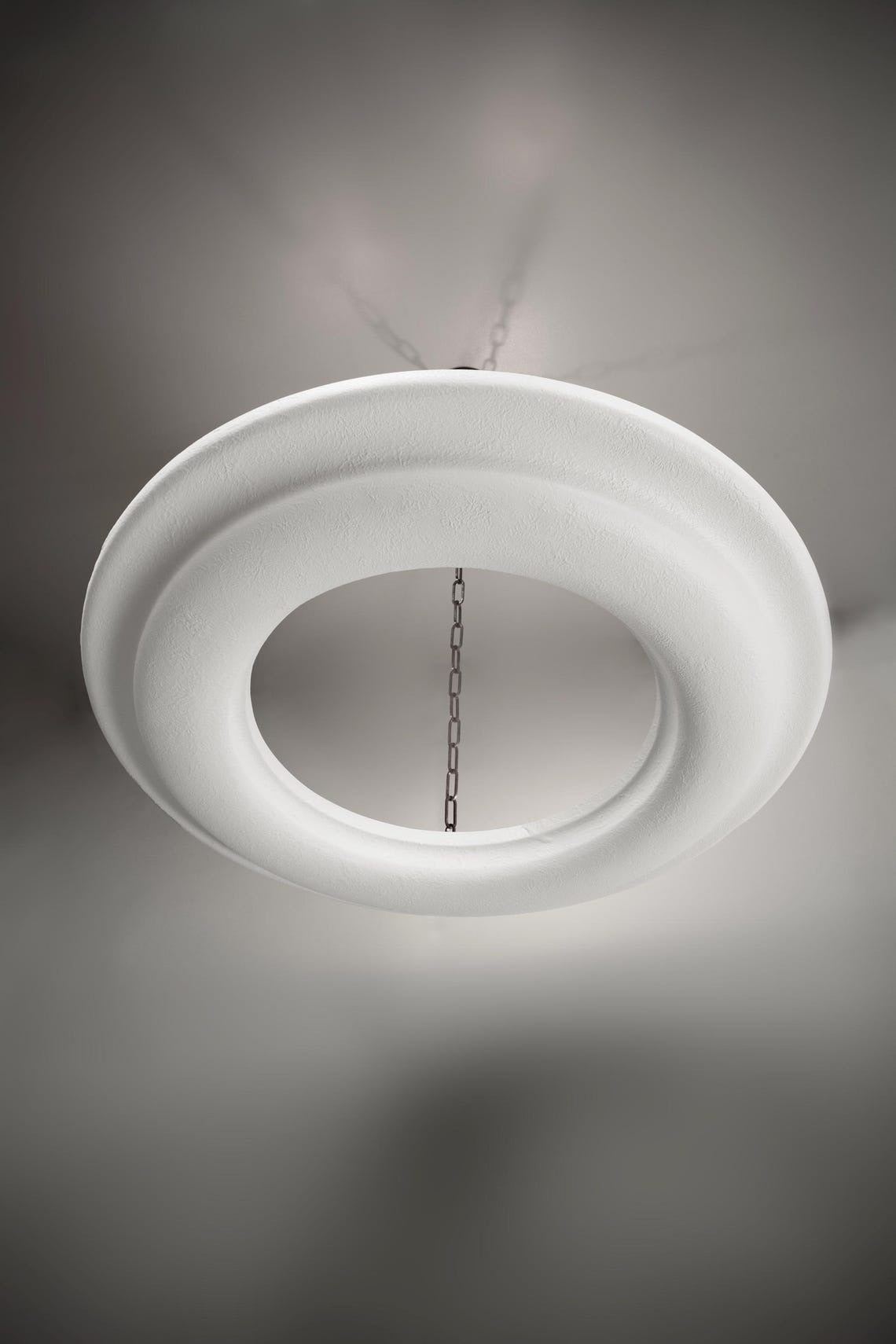 White circular chandelier with a textured surface, hanging from a chain.