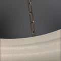 Close-up of a white textured light fixture with a chain.