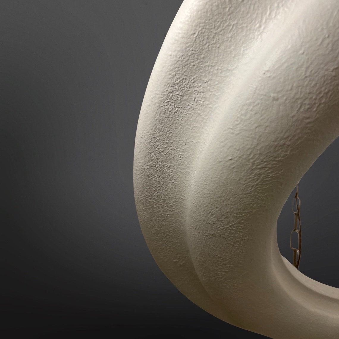 Close-up of a textured white circular light fixture against a dark background.