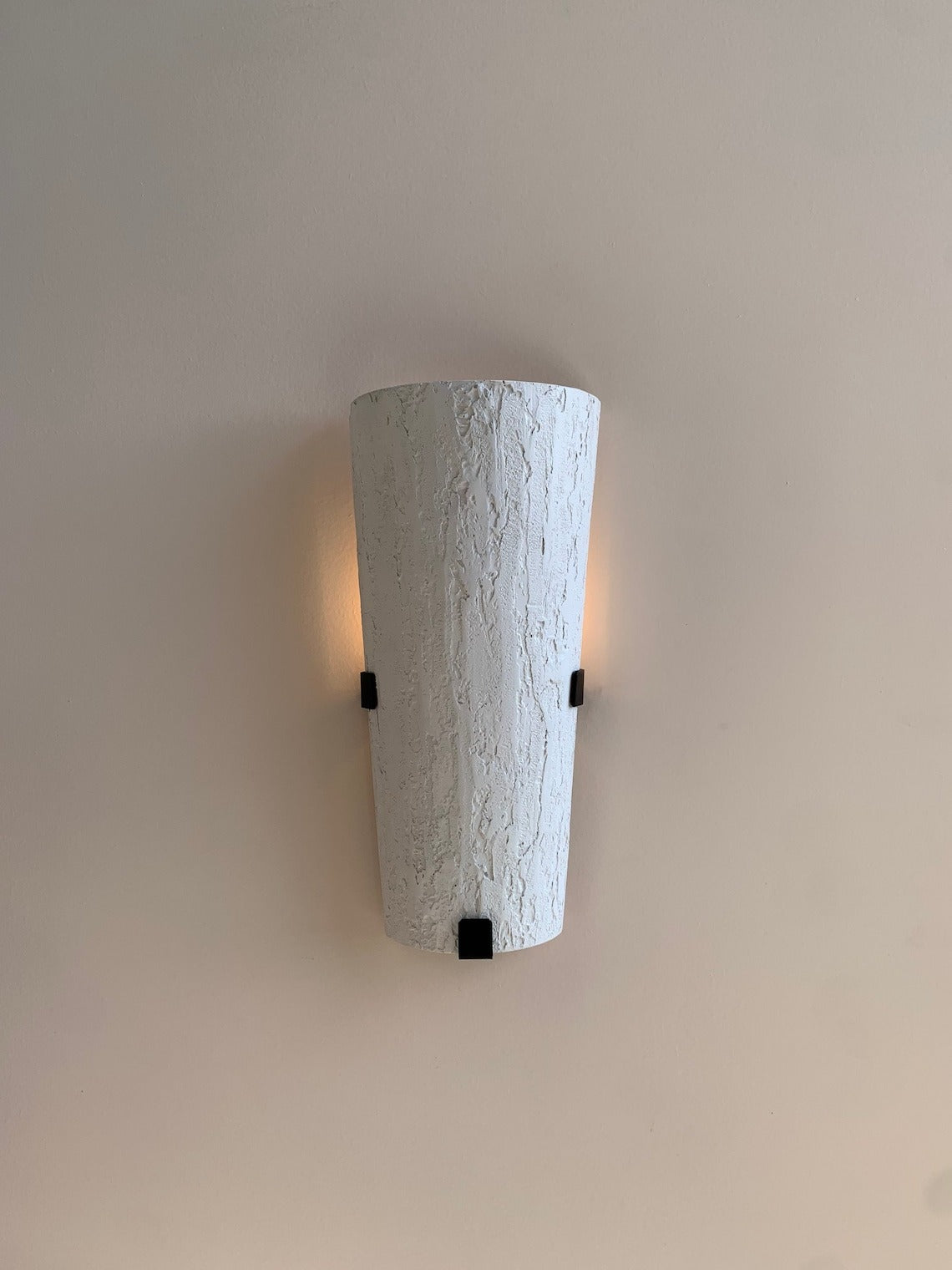 Textured white wall sconce with black accents.