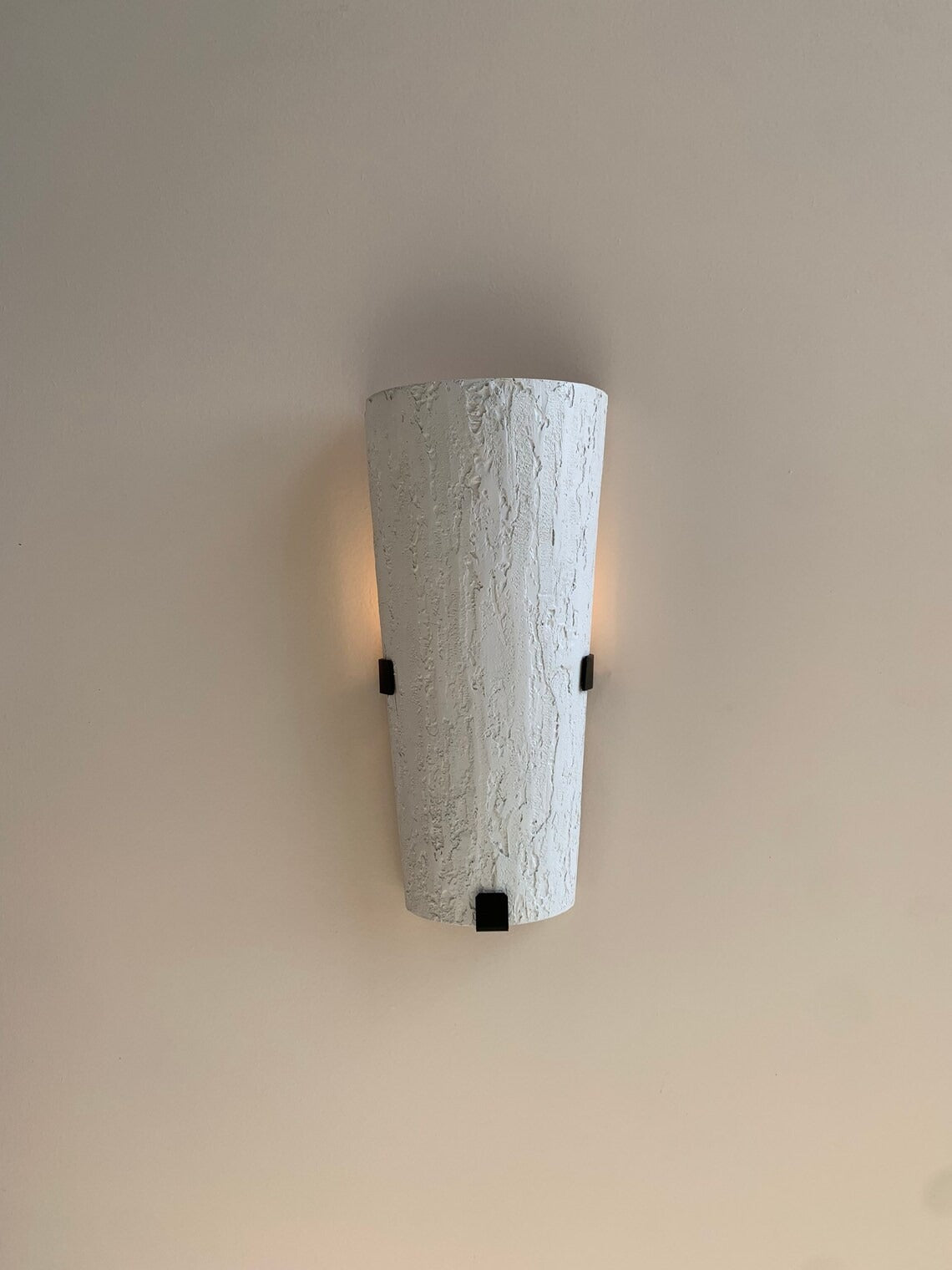 Textured white wall sconce with black accents.