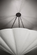 A close-up, low-angle view of a large, white fluted chandelier.