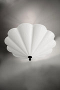 A large, white fluted chandelier hangs from a dark ceiling plate.