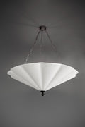 A large, white fluted chandelier hangs from a dark ceiling plate by chains.