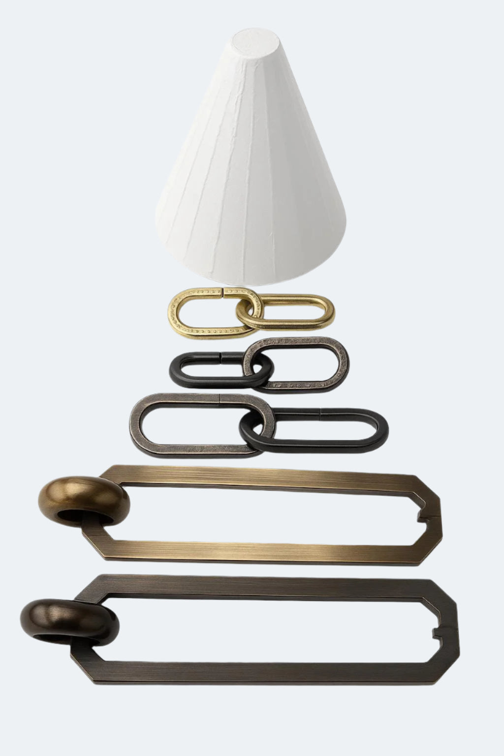 A display of various metal chain links in different finishes (brass, black, bronze) and two elongated metal handles, arranged below a white plaster cone shape.